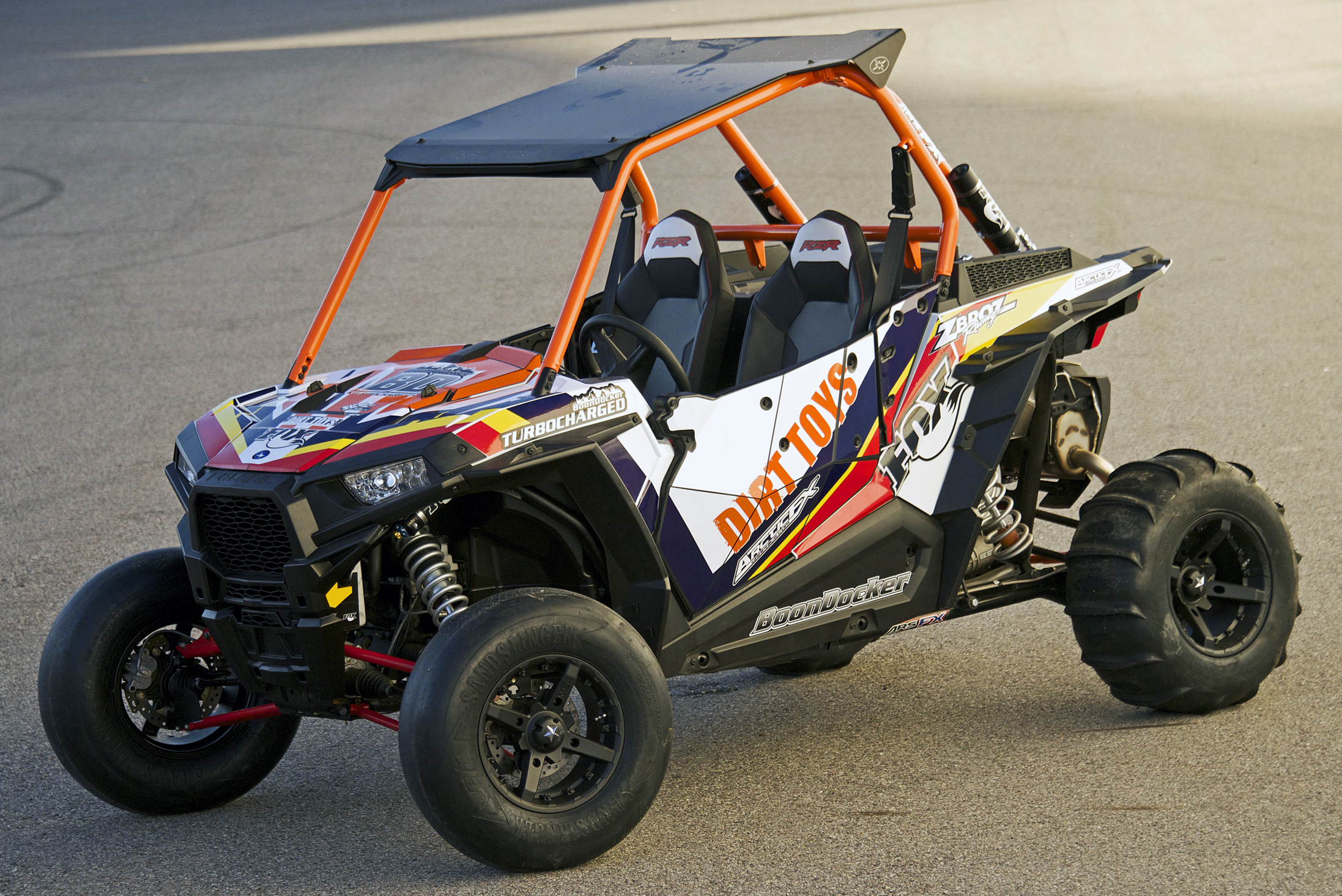 A Polaris RZR XP 2 Door side-by-side with a red, white, and yellow stripes Pursuit custom vinyl wrap.