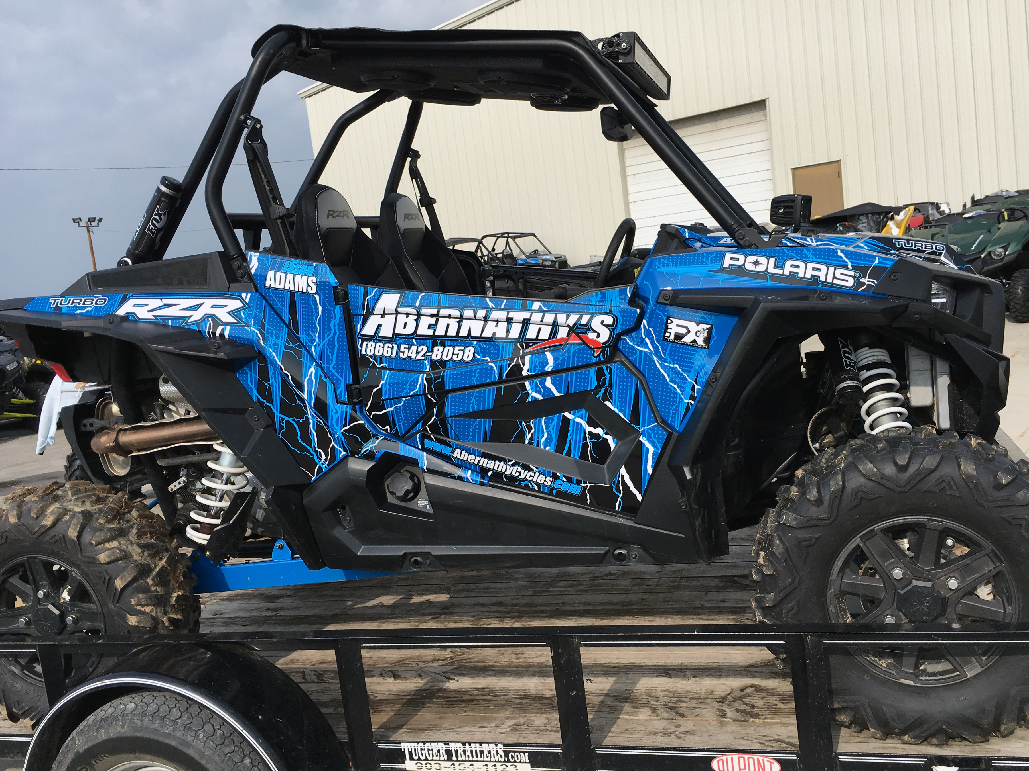 A Polaris RZR XP 2 Door side-by-side with a blue, black, and white lightning design Vitalize custom vinyl wrap.