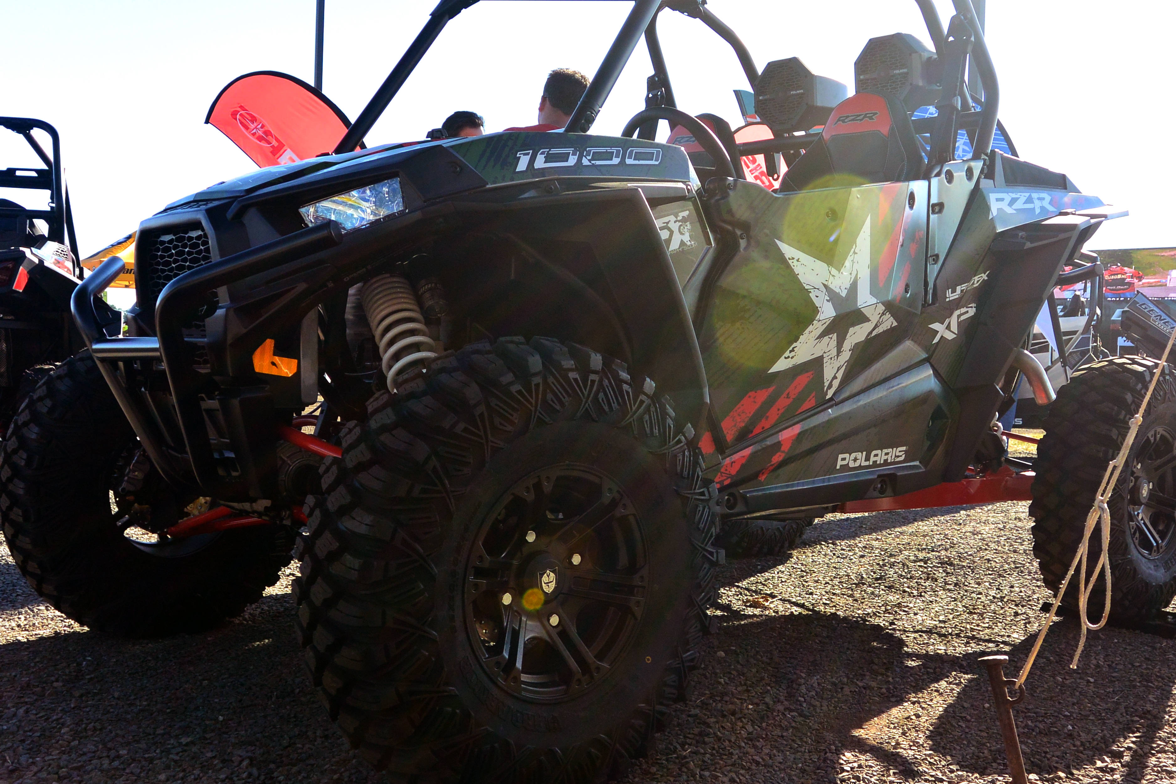A Polaris RZR XP 2 Door side-by-side with a army green, red, and black grunge Wartorn custom vinyl wrap.