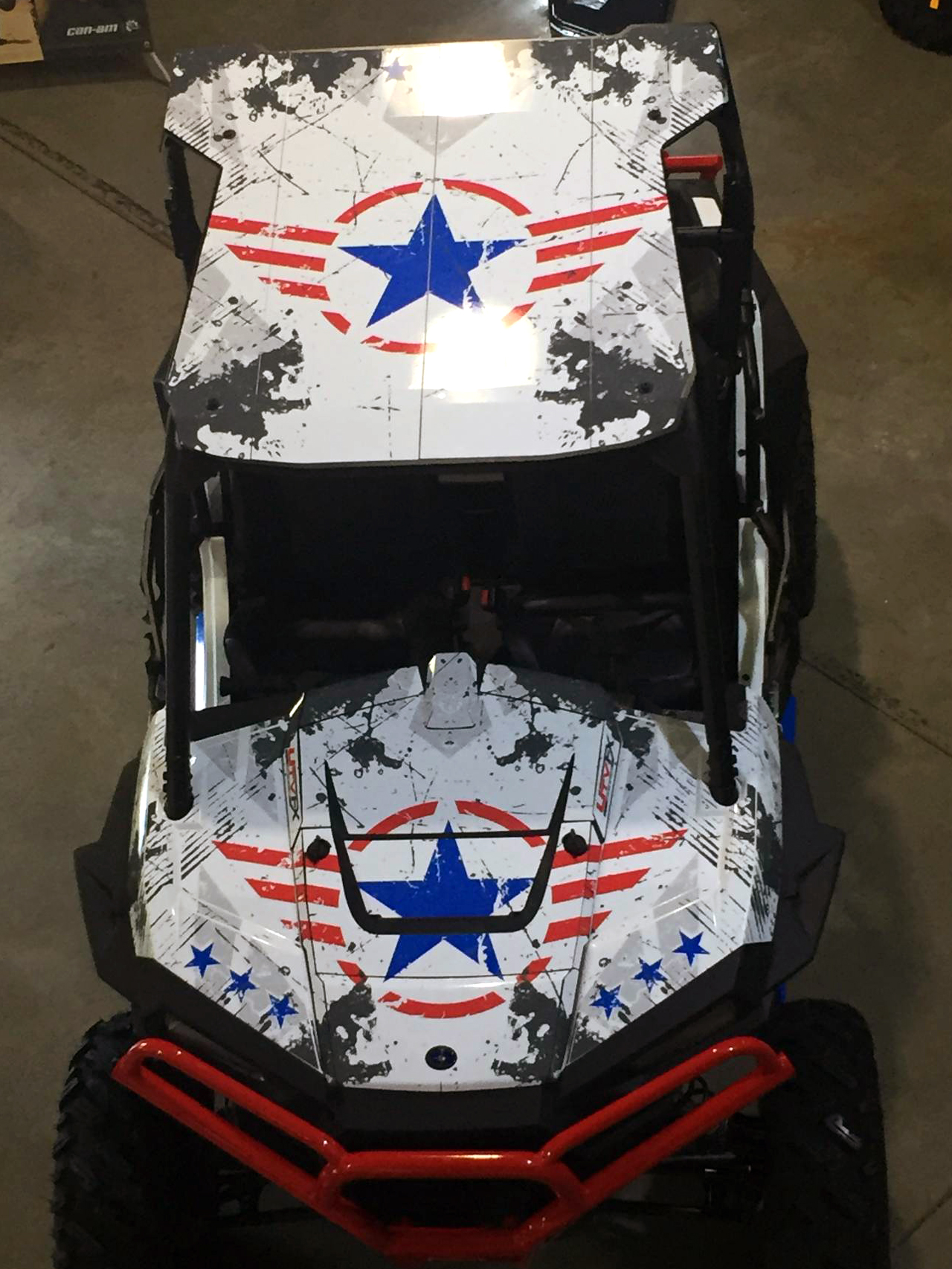 A Polaris RZR XP 2 Door side-by-side with a red, white, and blue grunge Wartorn custom vinyl wrap.