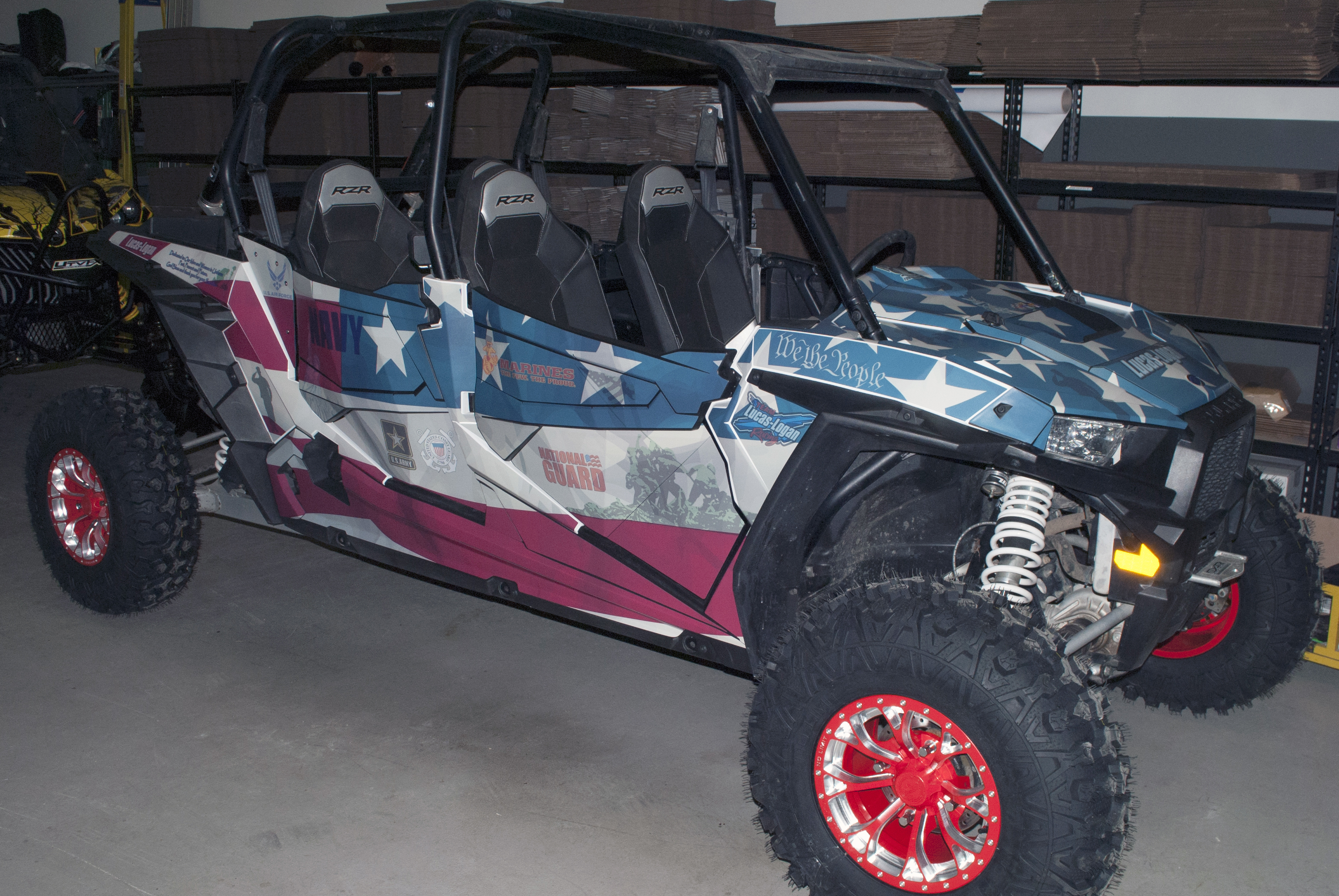 A Polaris RZR XP 4 Door side-by-side with a red, white, and blue American Fallen Heroes custom vinyl wrap.