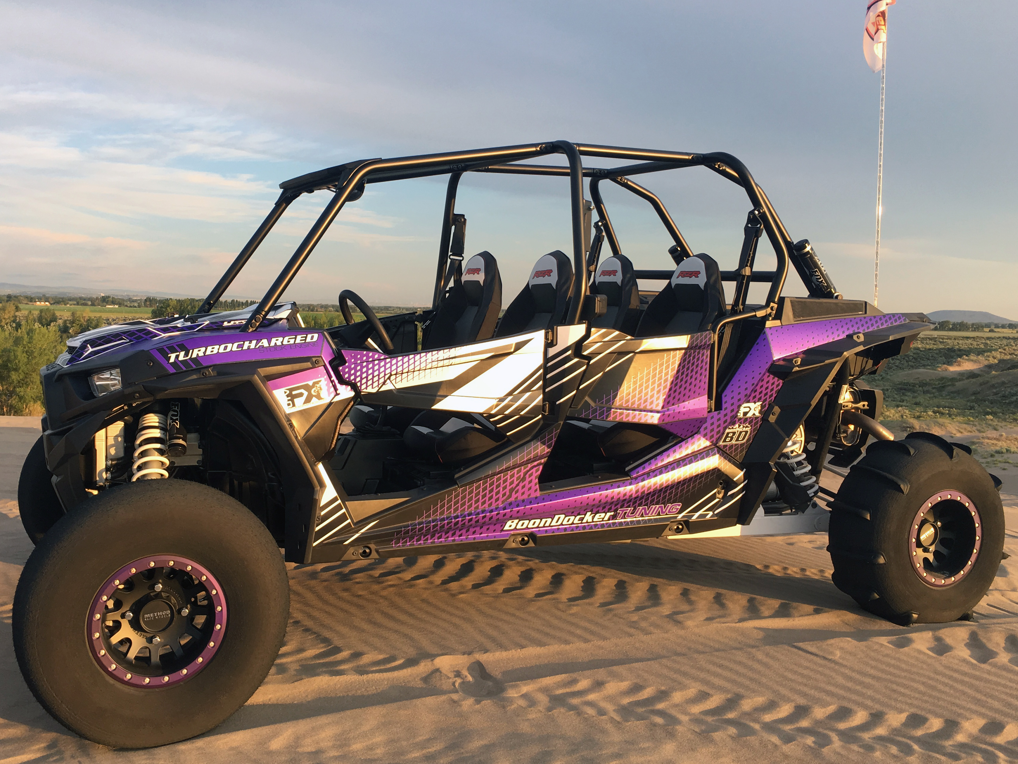 A Polaris RZR XP 4 Door side-by-side with a black, purple, and gray line design Parallel custom vinyl wrap.