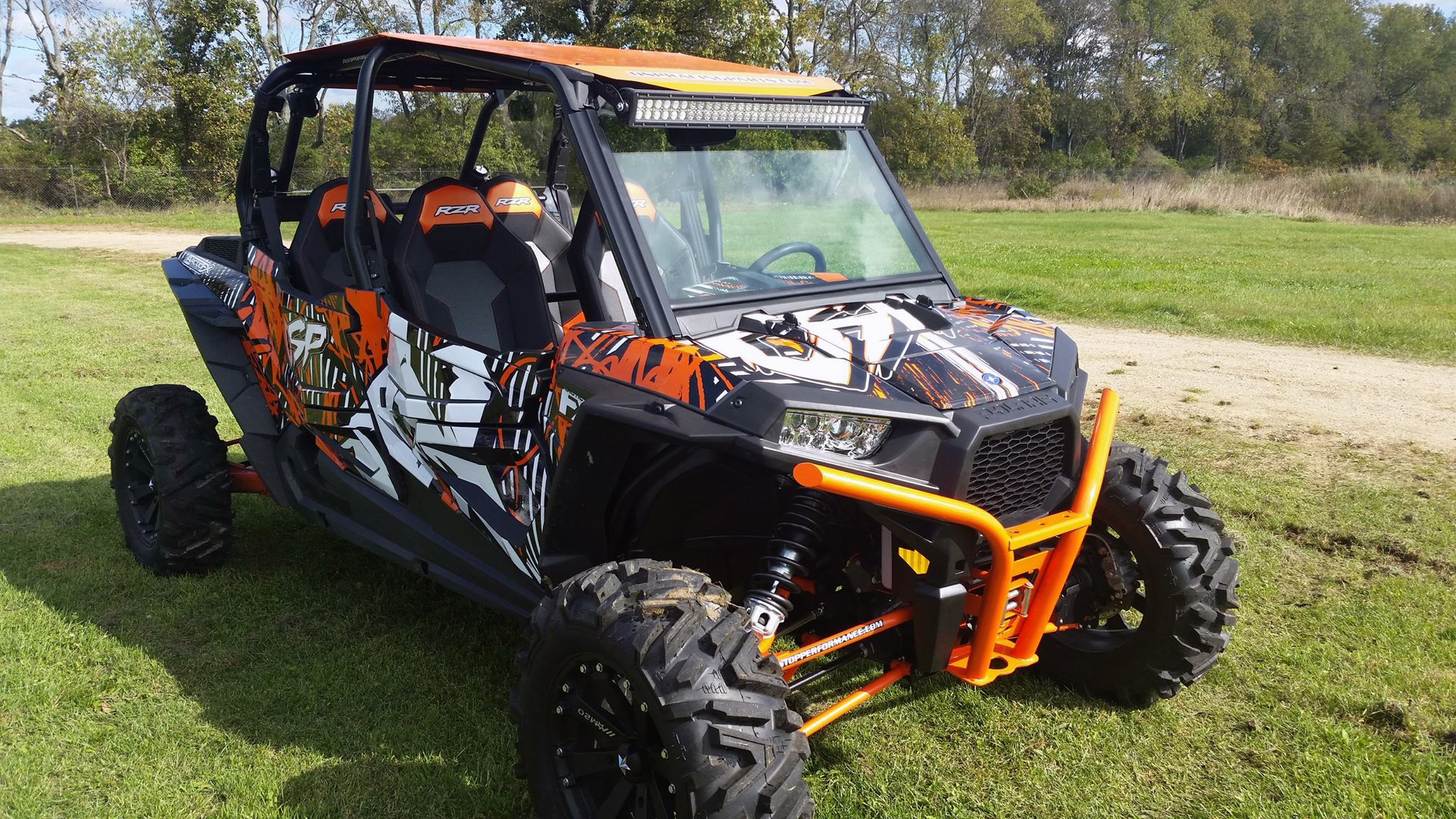 A Polaris RZR XP 4 Door side-by-side with a black, white, and red grunge abstract Scrib custom vinyl wrap.