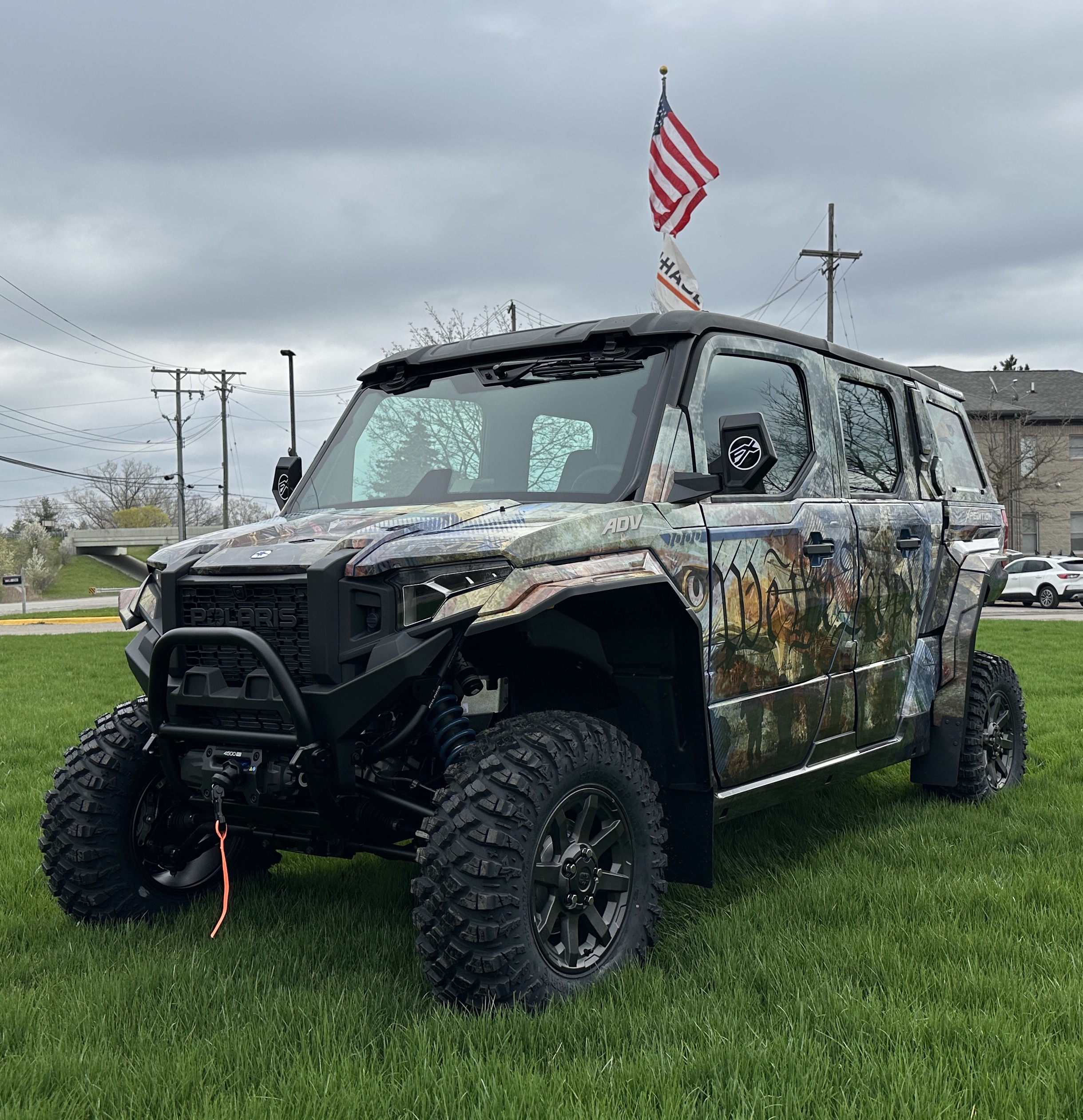 A Polaris Xpedition 4 door side-by-side with a We the People custom vinyl wrap.