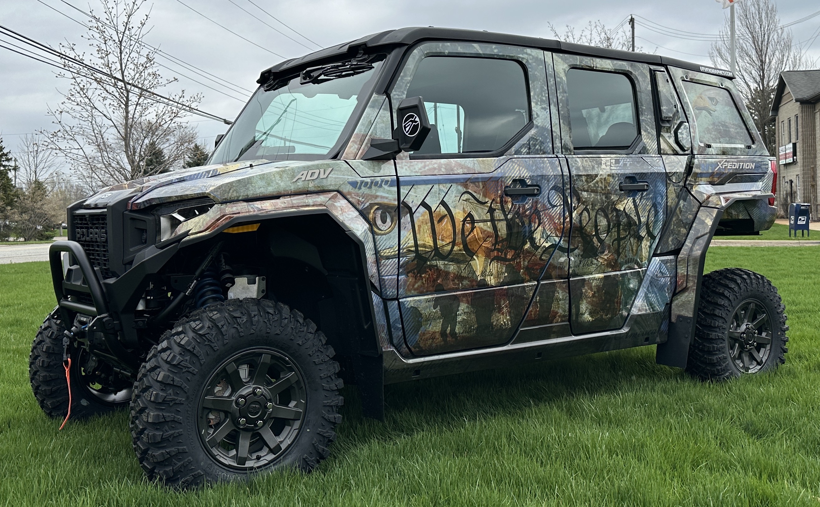 A Polaris Xpedition 4 door side-by-side with a We the People custom vinyl wrap.
