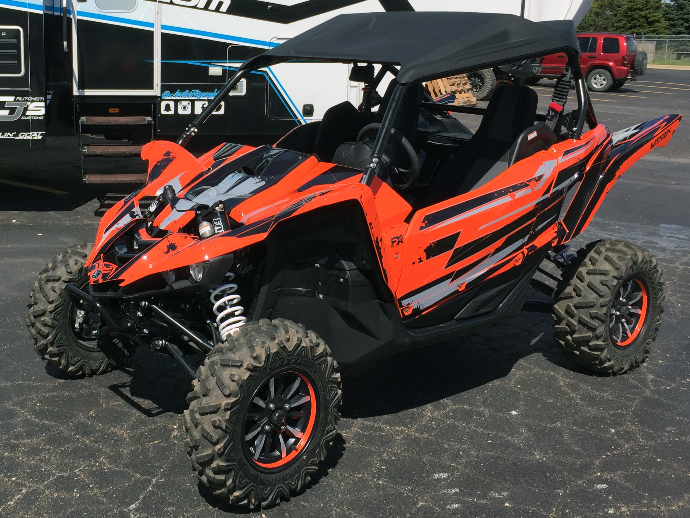 A Yamaha YXZ1000R side-by-side with a orange, black, and gray grunge stripe Race custom vinyl wrap.