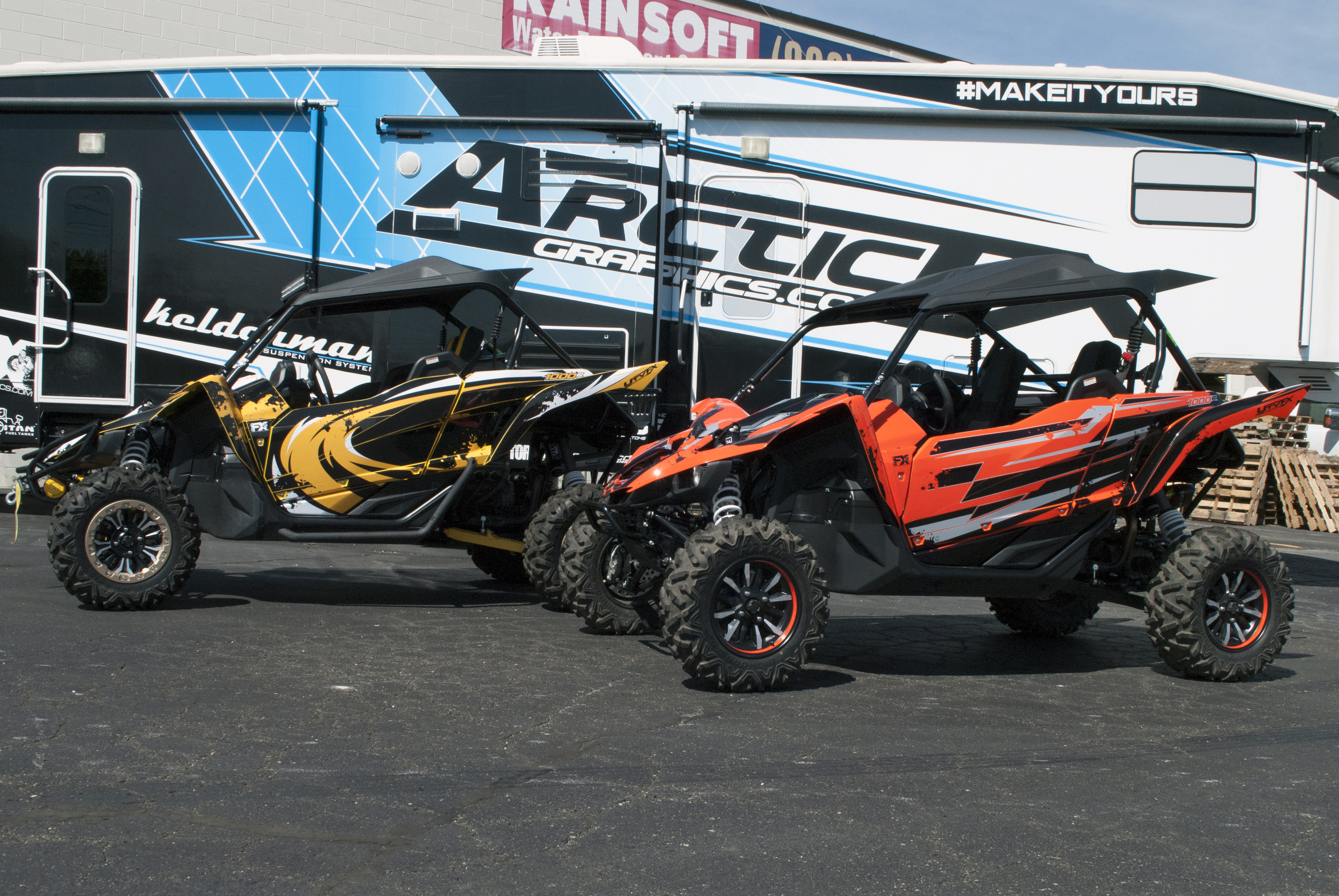 A pair of Yamaha YXZ1000R side-by-sides with a colorful unique custom vinyl wraps.