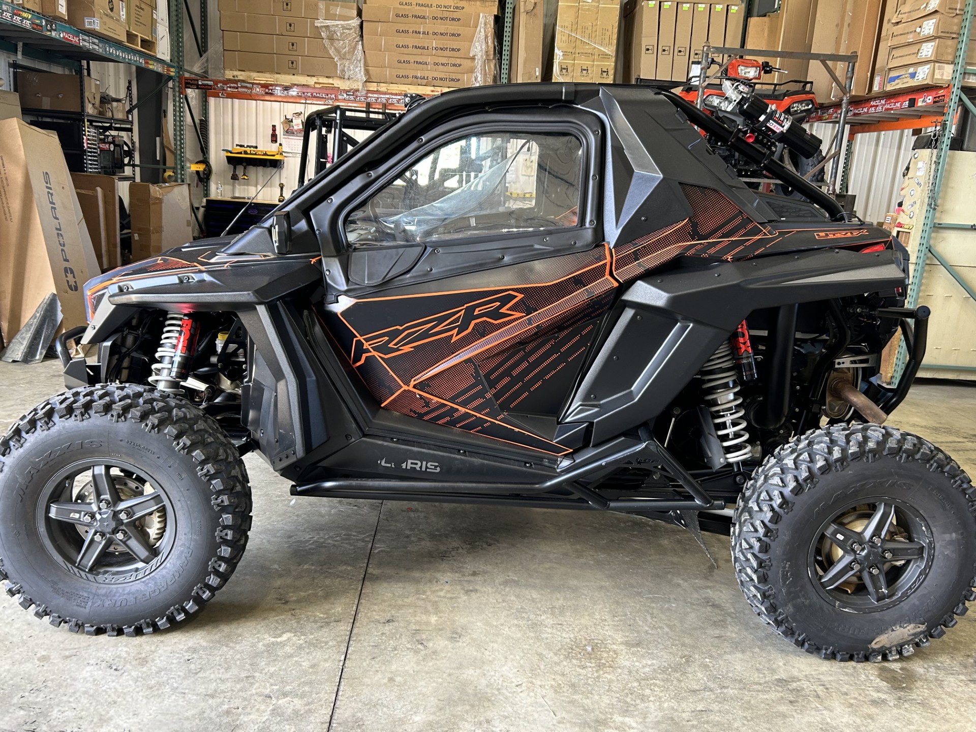 A Polaris RZR PRO XP 2 Door side-by-side with a black and axys burst Armada custom vinyl wrap with matte laminate.